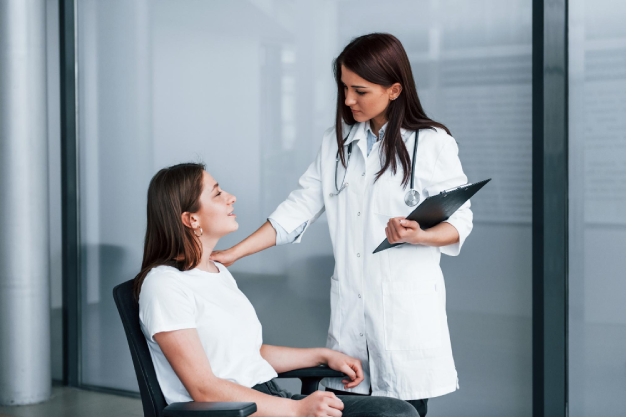 friendly-doctor-listening-patient-young-woman-have-visit-with-female-doctor-modern-clinic